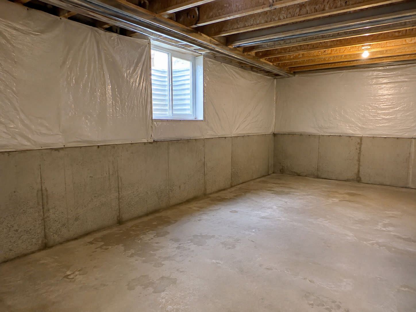 Unfinished basement with bare joists and concrete floor