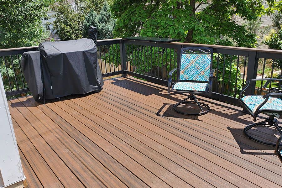 Wood deck with black railing among trees