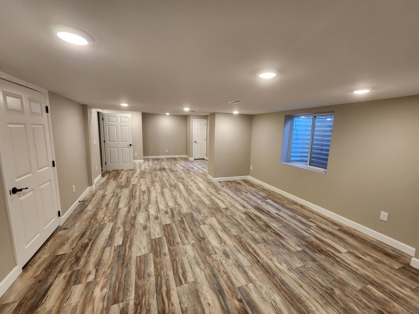 Finished basement hallway with wood-look flooring