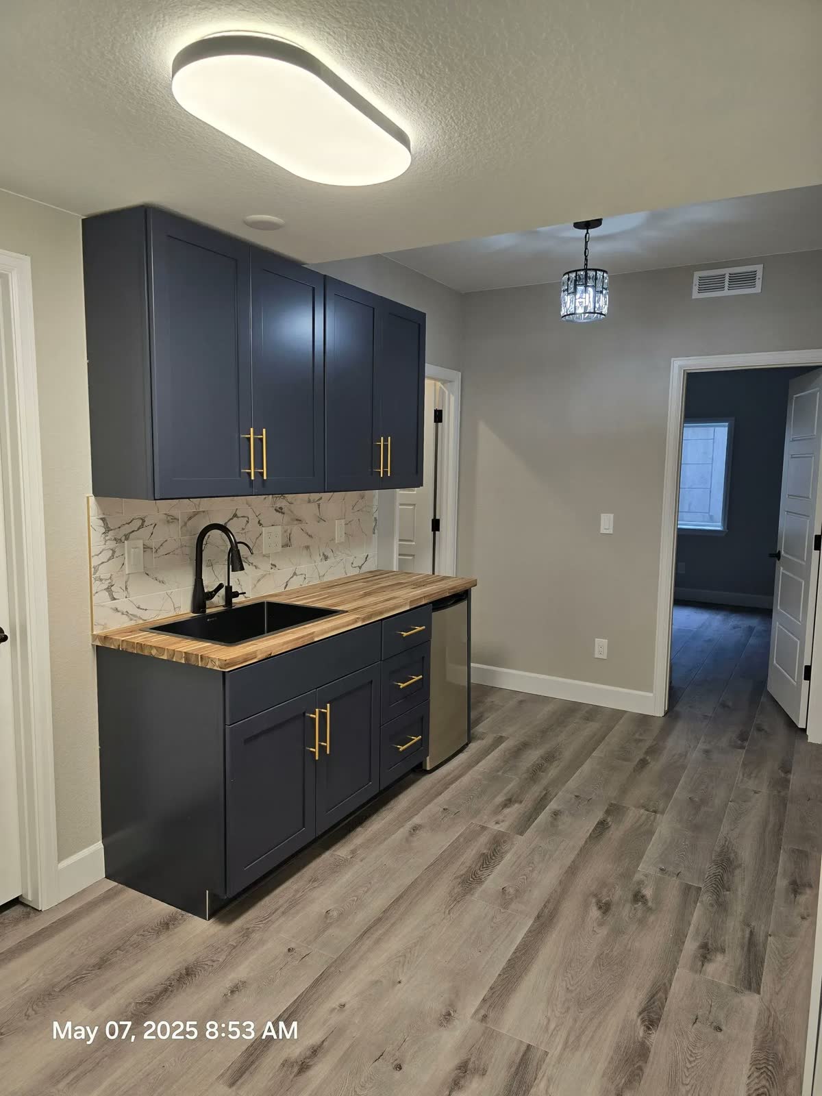 Navy cabinet kitchenette with brass hardware