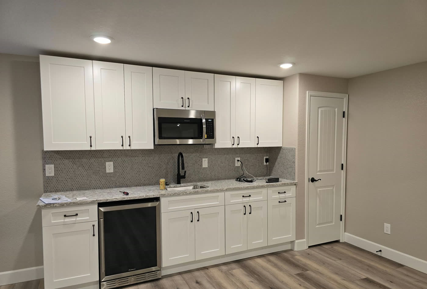 White shaker basement kitchenette