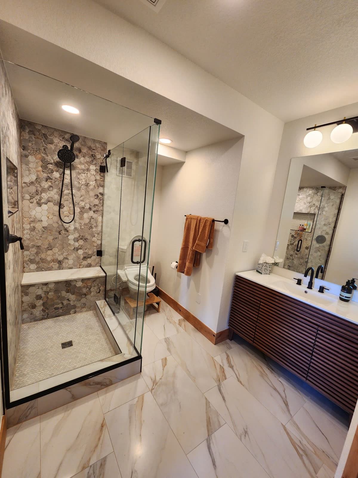 Stone-tile shower with glass enclosure
