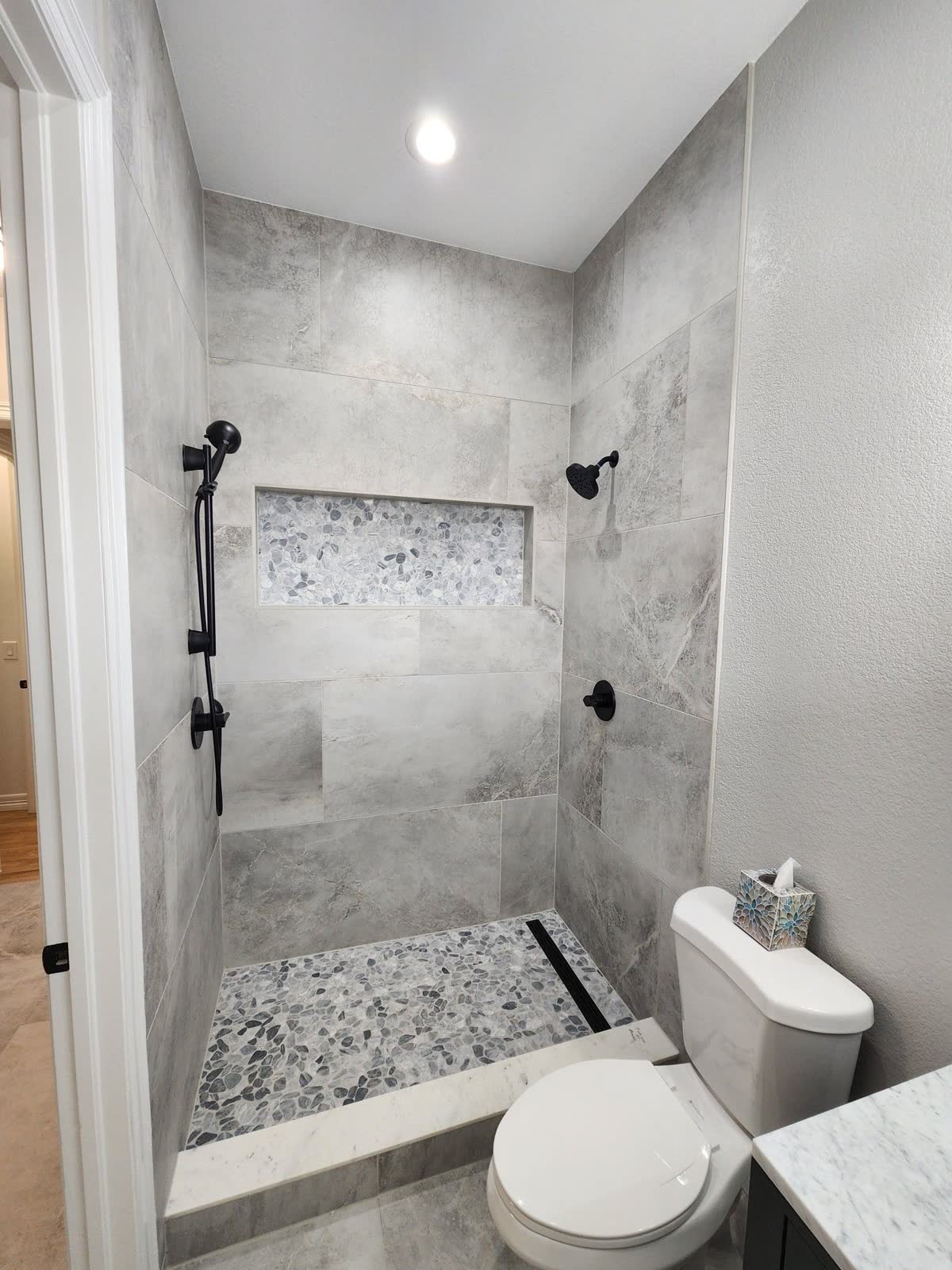 Tiled walk-in shower with pebble floor