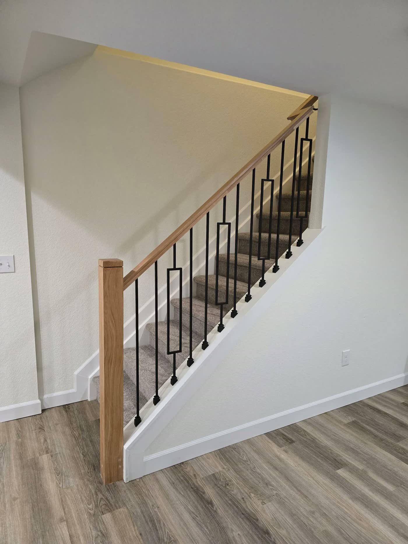 New basement staircase with iron balusters and oak rail