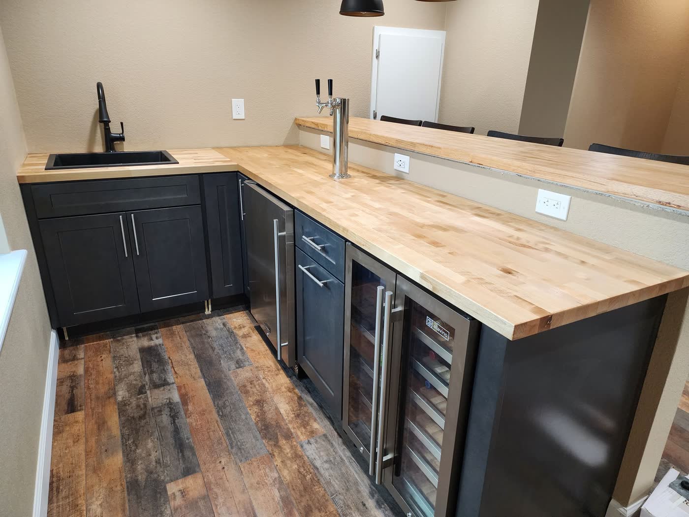 Basement wet bar with butcher-block counter and navy cabinets